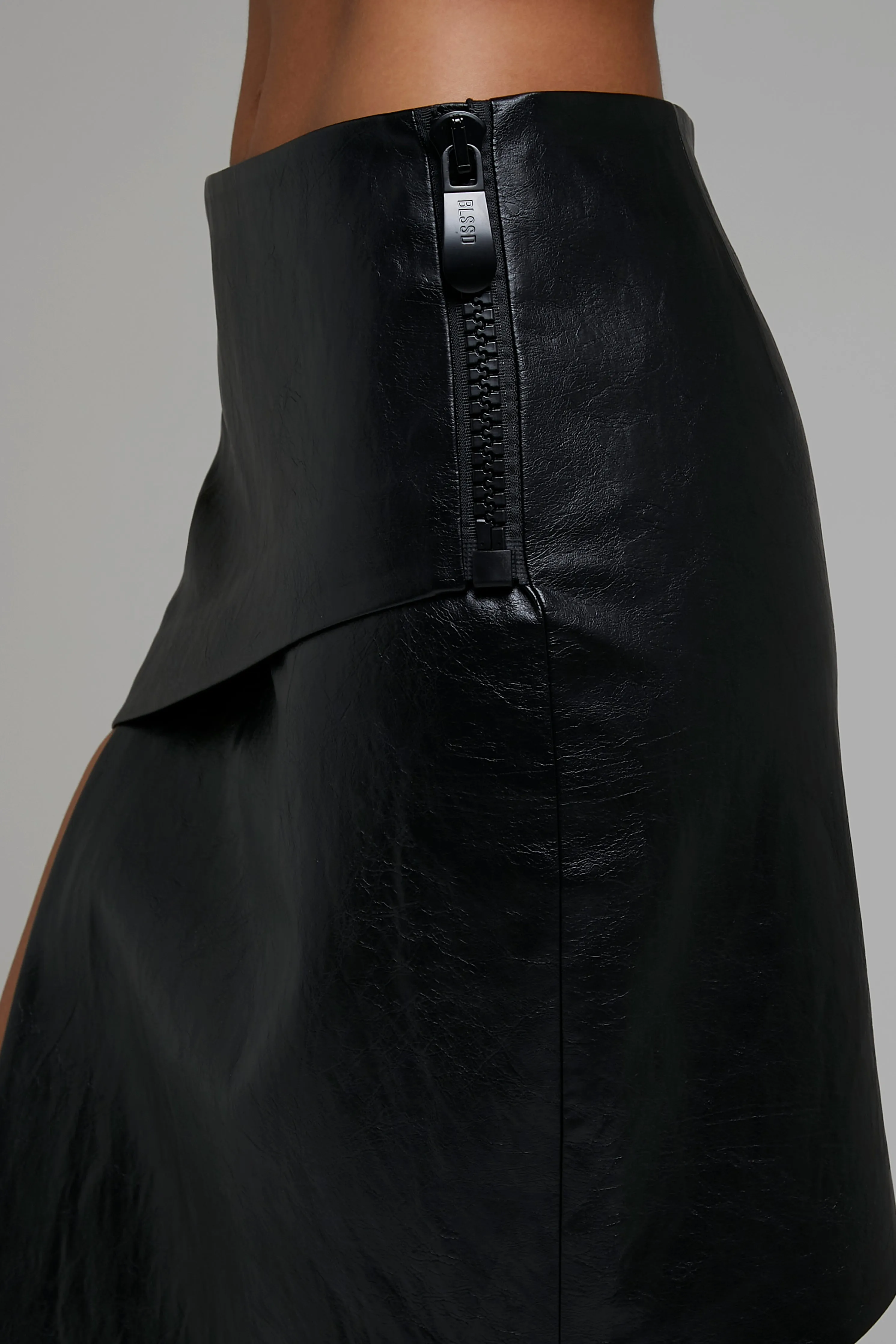 VEGAN LEATHER ASYMMETRIC WRAP SKIRT W/ CHUNKY ZIPPER